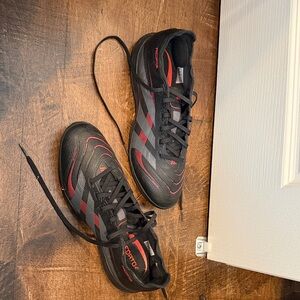 Adidas Men's Black and Red turf soccer cleats.
